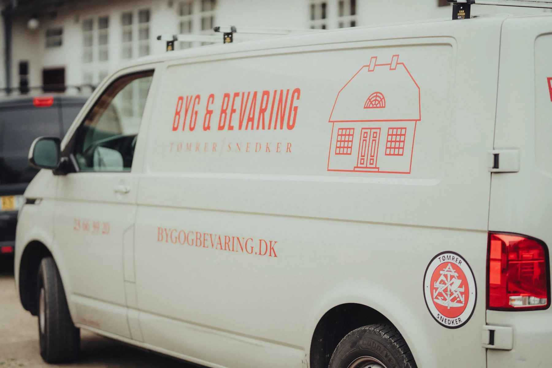 Hvid Byg & Bevaring-varebil med logo, telefonnummer og bygogbevaring.dk på siden.